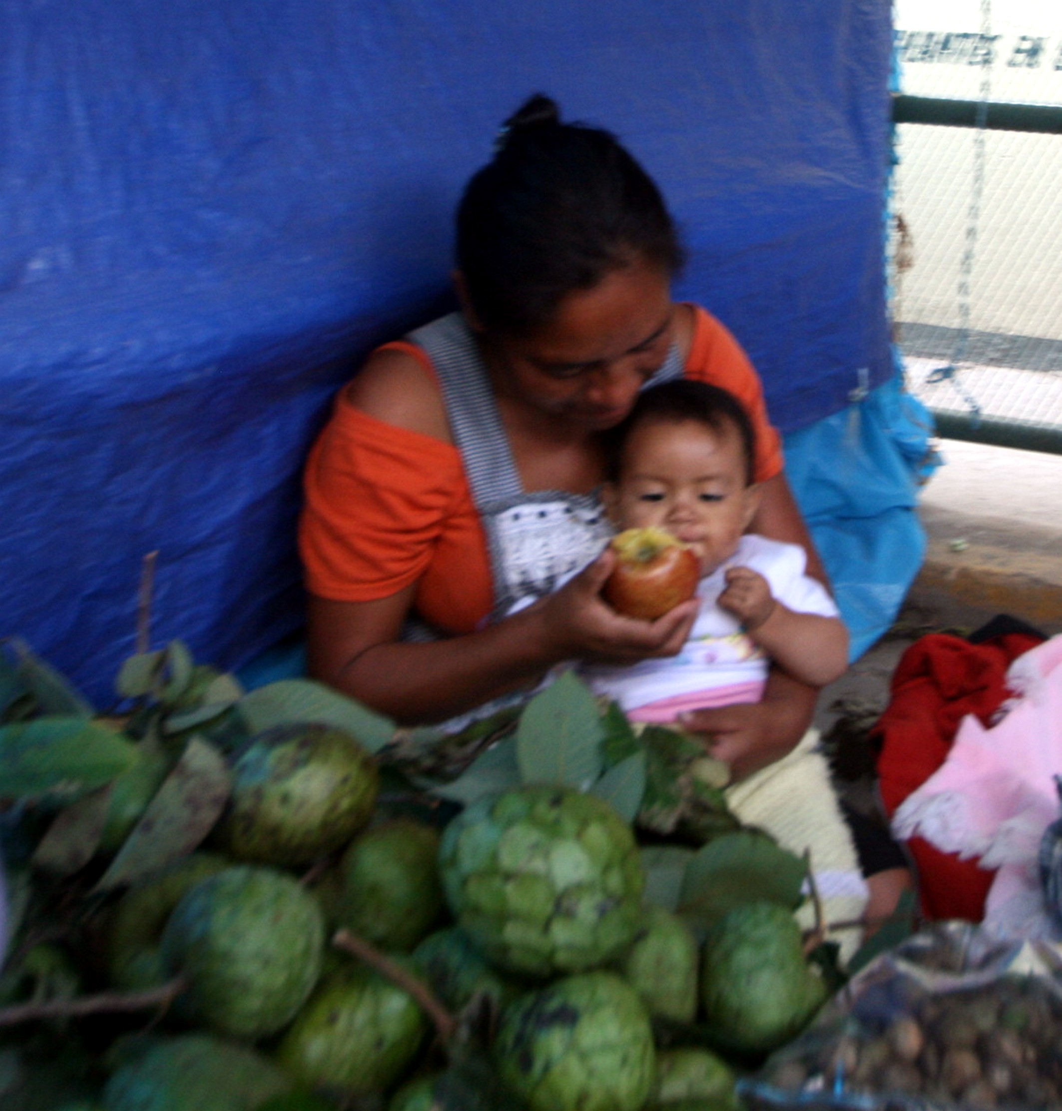 Mercado del dia de muertos en Tlacolula, Mujer alimentando niño